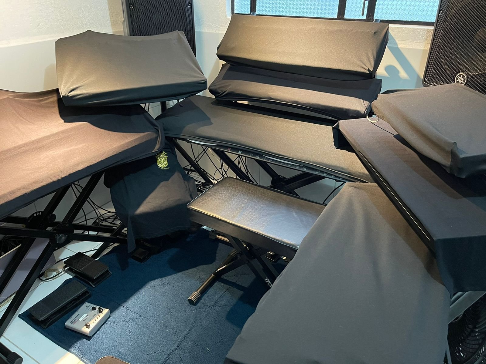 Conjunto de teclados cobertos com capas pretas em um estúdio
